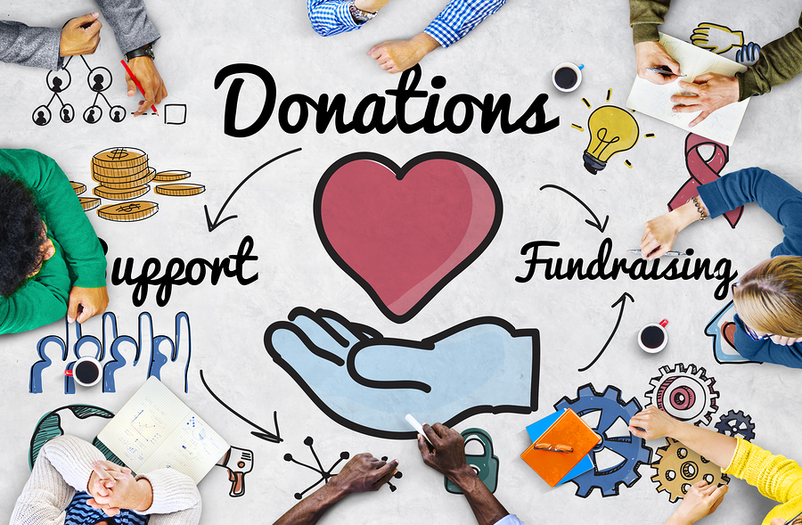 People sit around the edge of the image and draw different symbols around a central graphic of a heart and a hand that are titled “Donations”. 