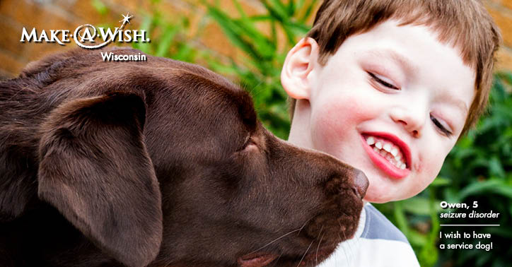 The Make-A-Wish logo marks the corner of a photograph of a grinning little boy, who is face-to-face with his new chocolate lab.